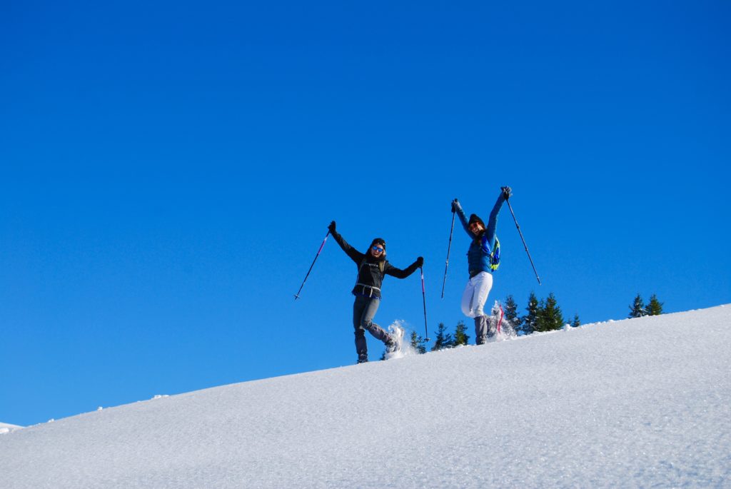 snowflike- femmes joyeuses en raquettes à neige dans la neige poudreuse