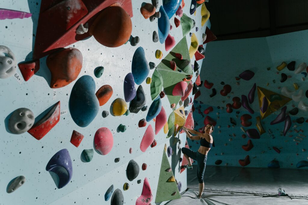 Grimpeuse de bloc au pied du mur d'escalade.