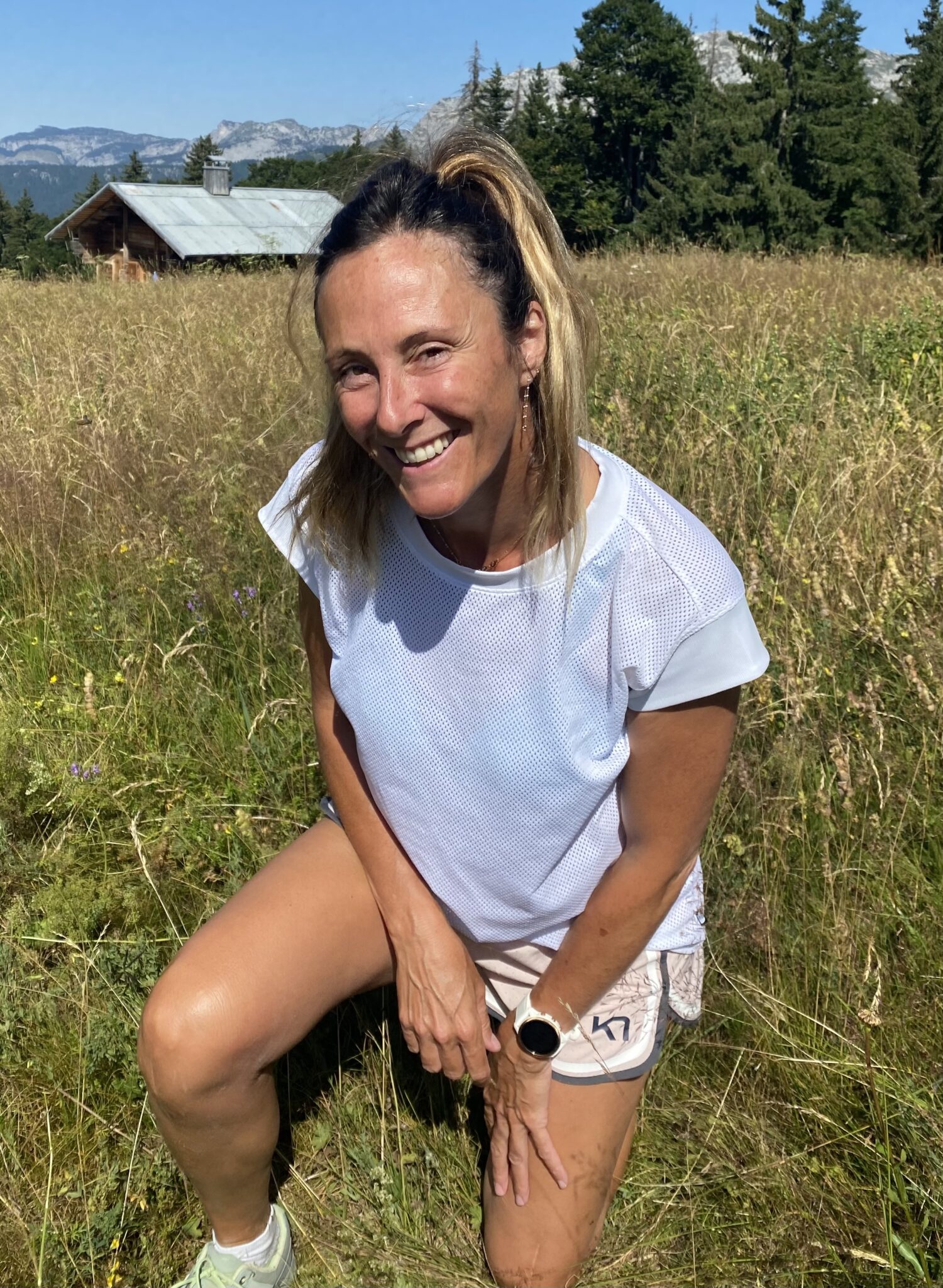 Portrait de Fanny Caspar, agenouillée dans le pré de Parmis à La Clusaz.